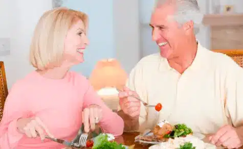 Um casal de idosos felizes se alimentando.